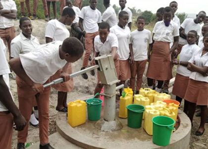students pumping water from borehole