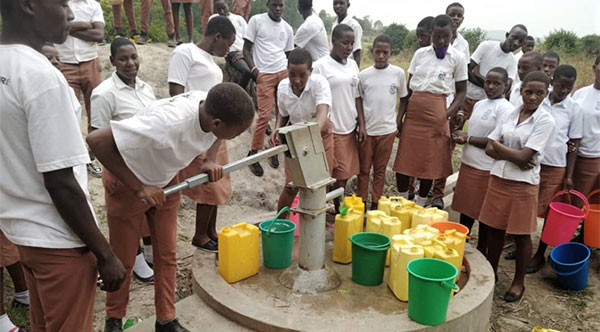 students pumping water from borehole