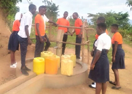 students at borehole in uganda