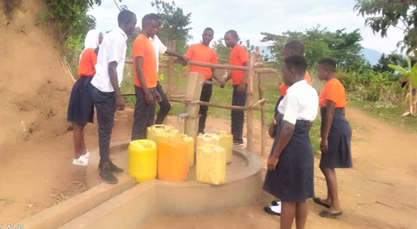 students at borehole in uganda