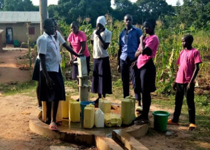 Students getting water from a borehole in Uganda